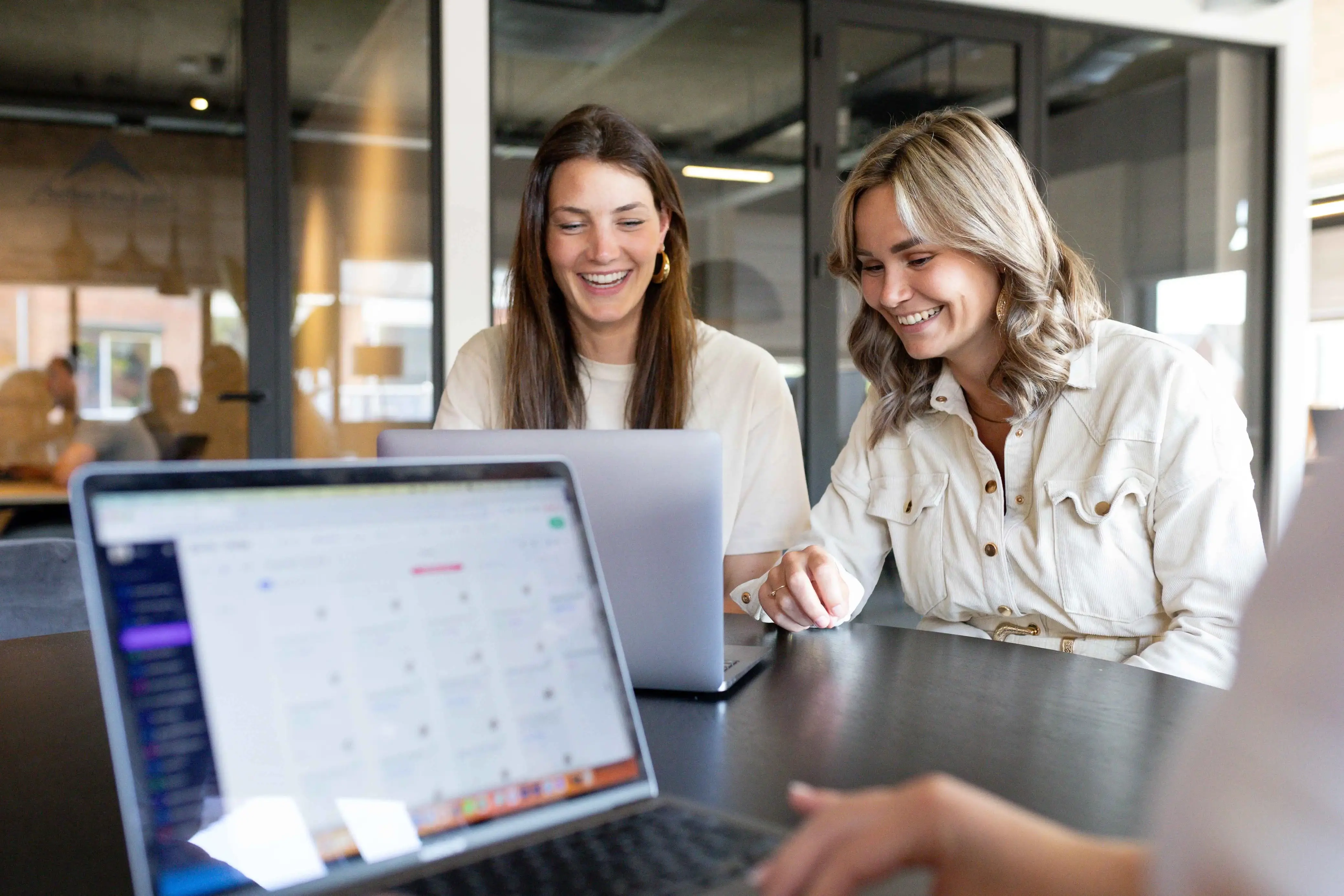 vPlan Kalender: Twee collega’s die op een laptop aan het kijken zijn naar hun planning in vPlan.