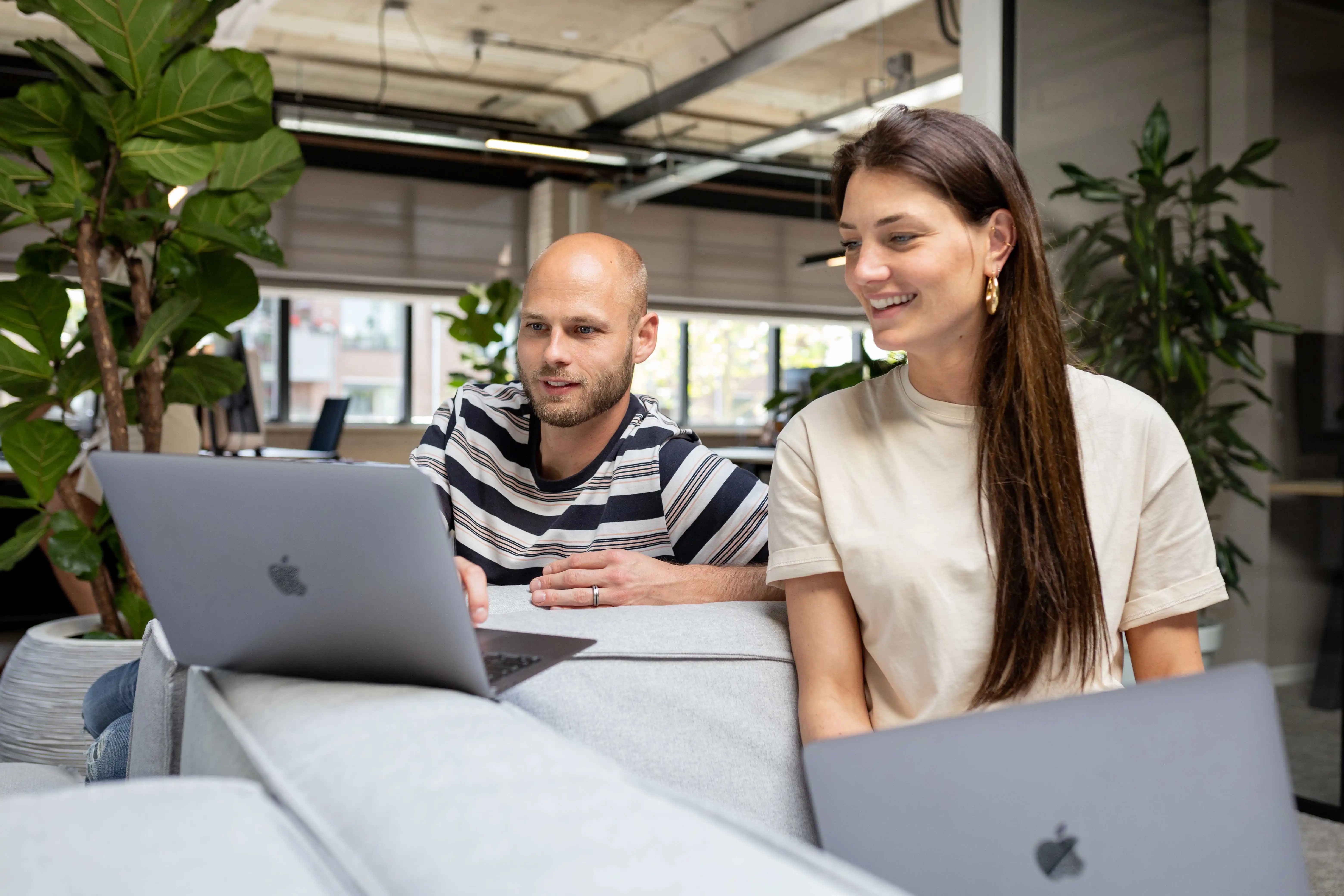 vPlan Kanban: Twee collega’s die aan het samenwerken zijn op hun laptop.